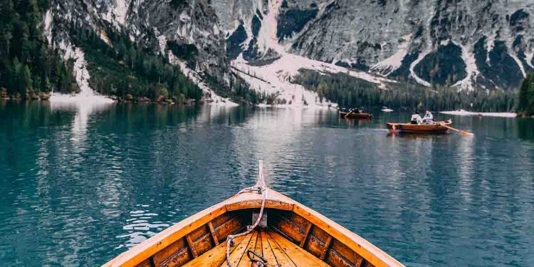 Boat in a lake surrounded by snow covered mountains