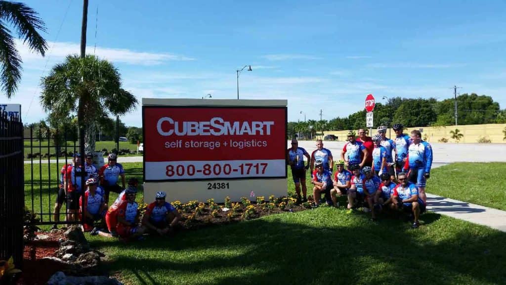 CubeSmart-Bonita-Springs-Self-Storage-Brotherhood-Ride-bicyclists-by-sign