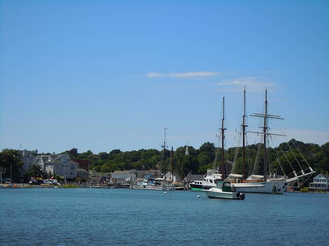 view of boats docked in the water and houses in the background in Mystic, CT