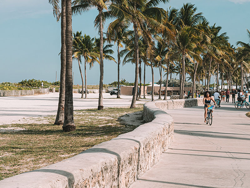 People walking and biking on a path in Miami Beach.