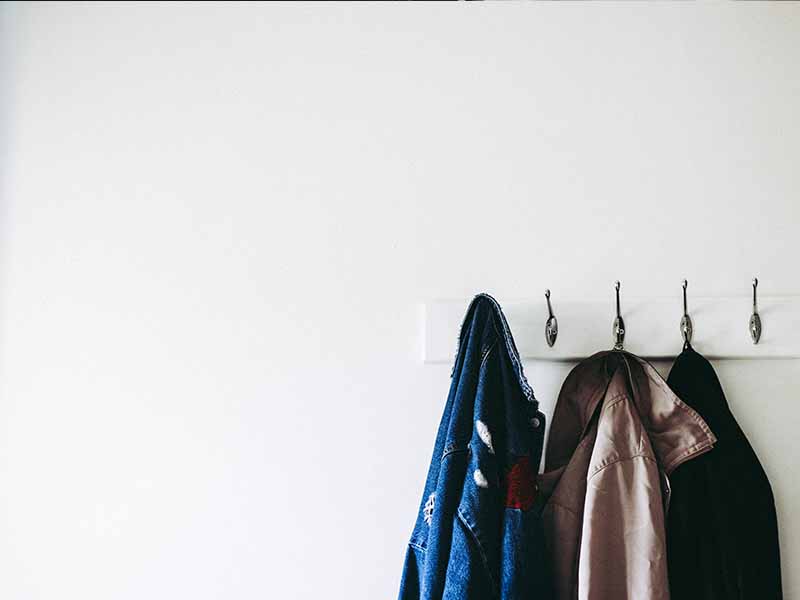Jackets hanging on a hook on a white wall