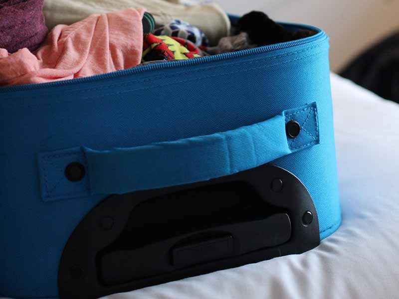 Untidy blue carry-on suitcase
