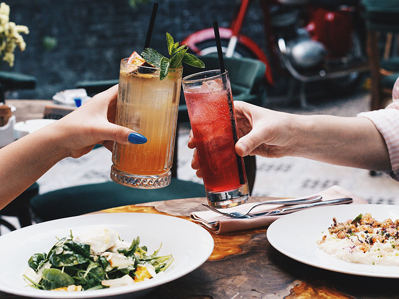 Two people at dinner with drinks and food.