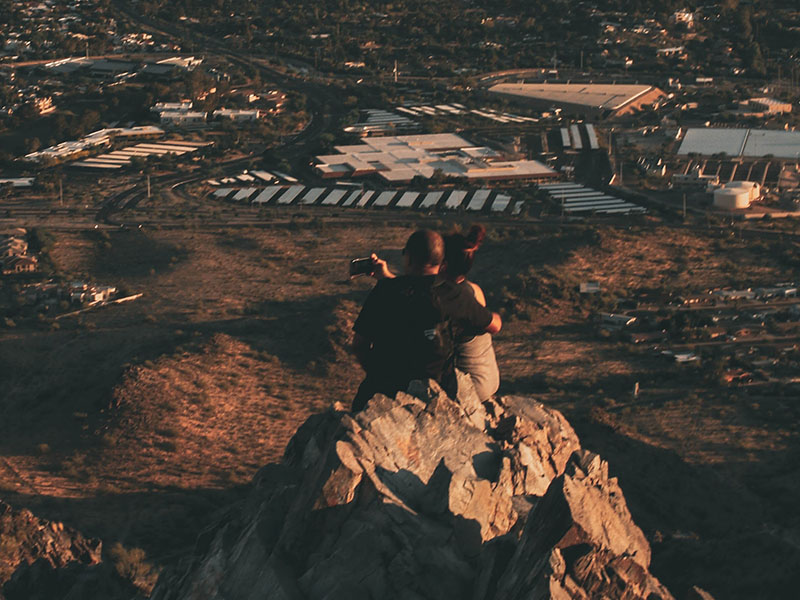 People sitting on rock formation in Arizona.