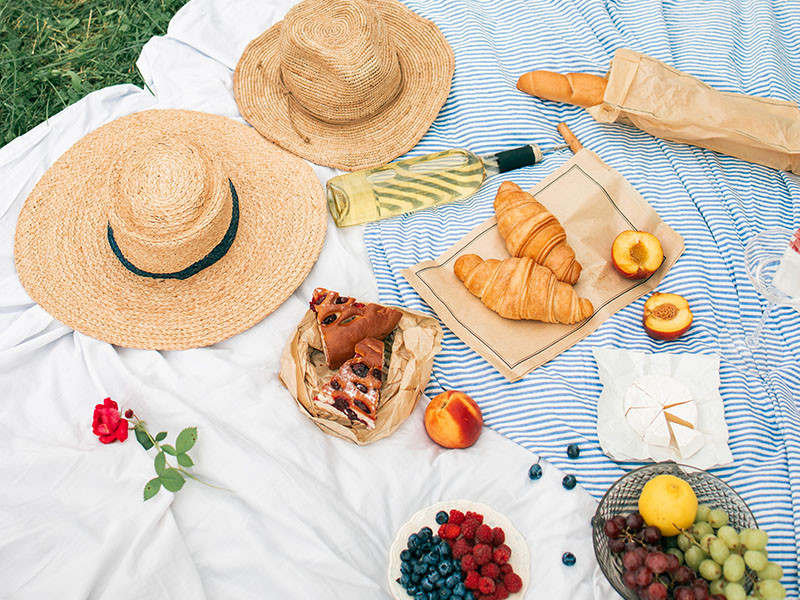 Picnic setup outside with food and drinks.
