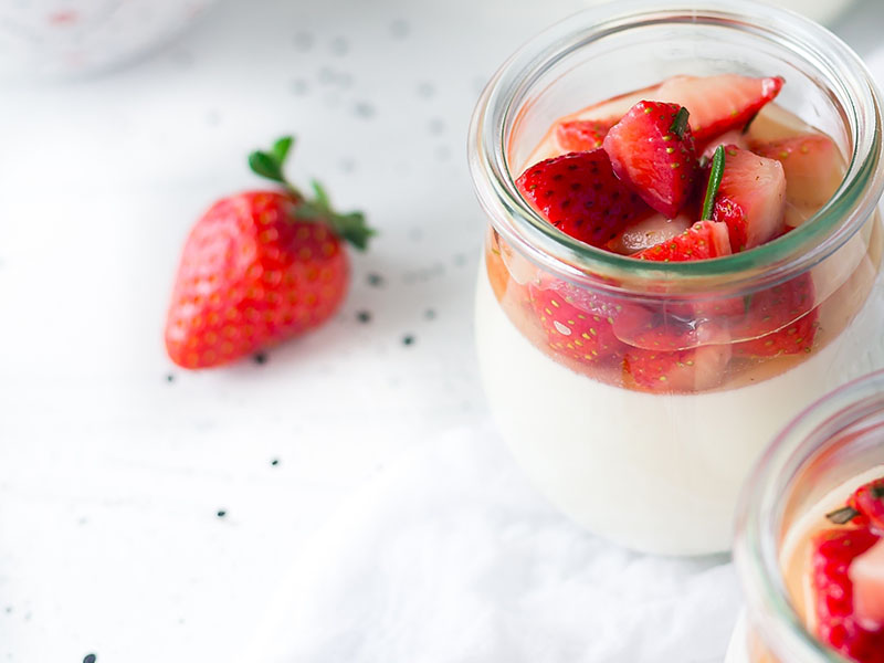 Strawberry yogurt in a glass container.