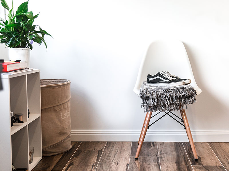 white chair with blanket folded on top next to cubed shelves