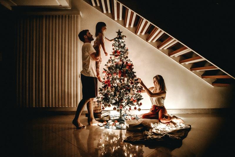 lit holiday tree with young family