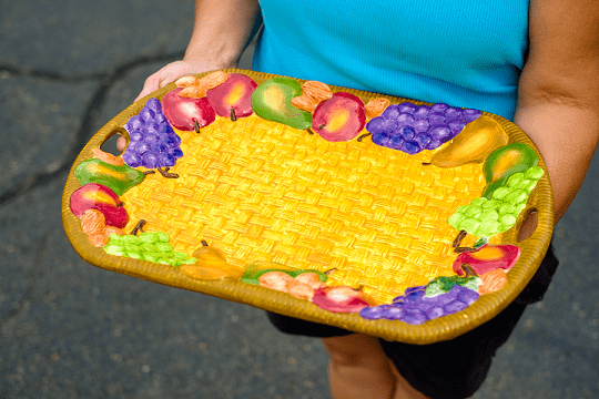 woman holding serving platter that has a fruit design