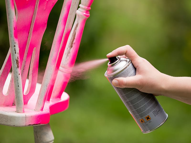 spray painting a wooden chair