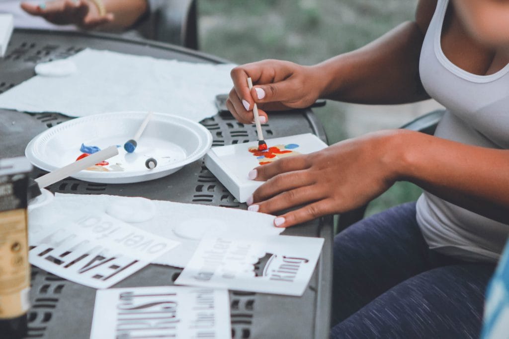 gap year - hands painting paper on a table