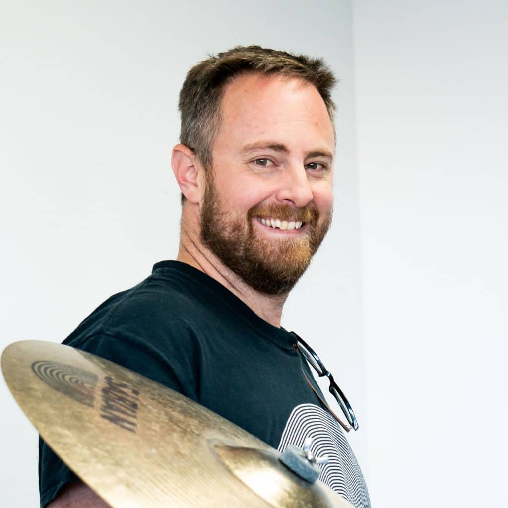 customer Adam Haman holding a drum snare at CubeSmart in Denver