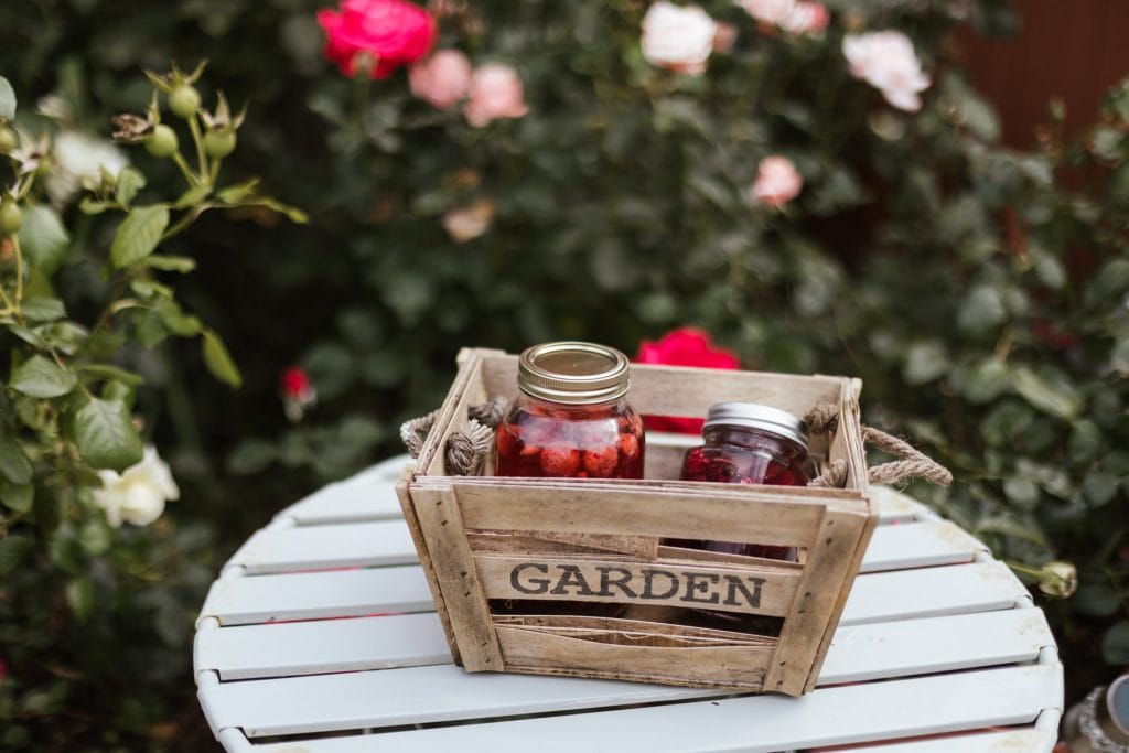 A crate with jars of jam in a garden
