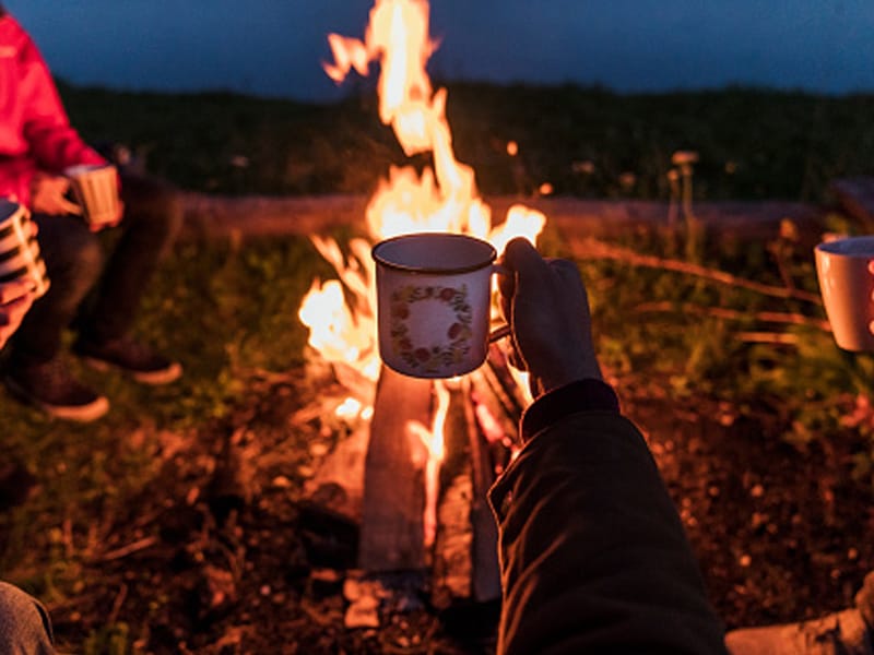 mug held up in front of campfire
