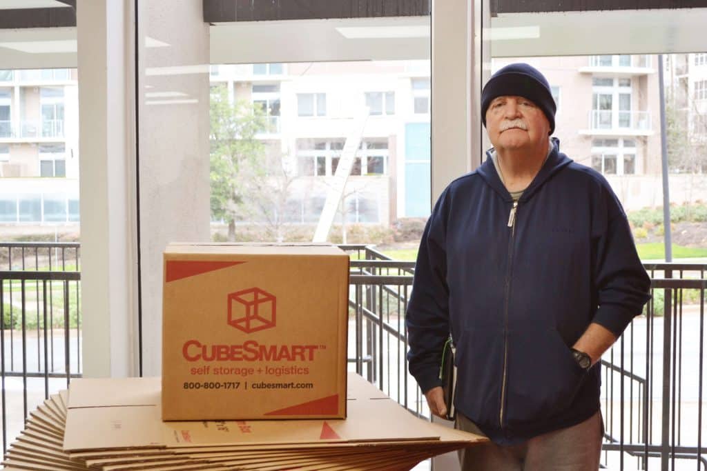 Bob Whilhite standing next to CubeSmart boxes