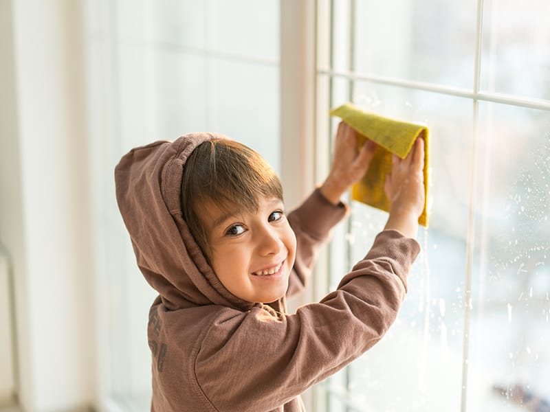 child wiping windows