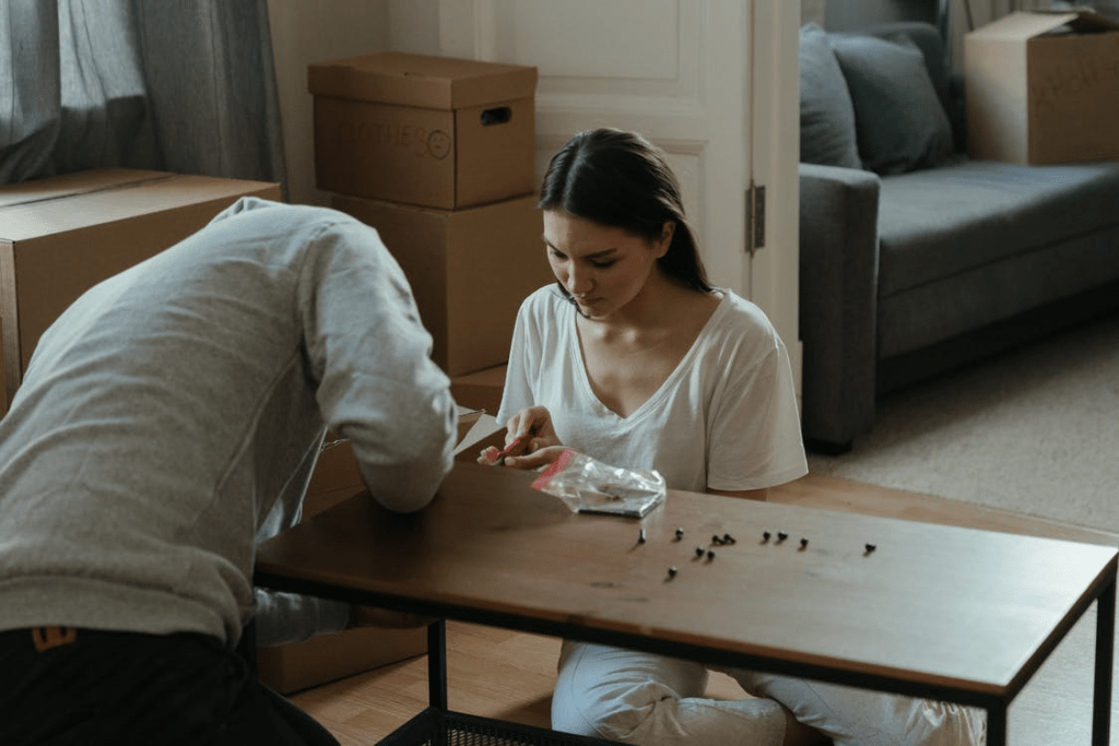Two people taking apart furniture