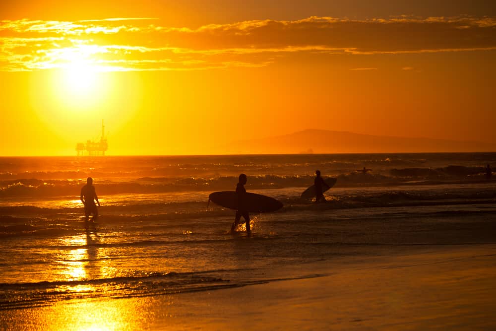 Surfers at sunset near Seal Beach, California