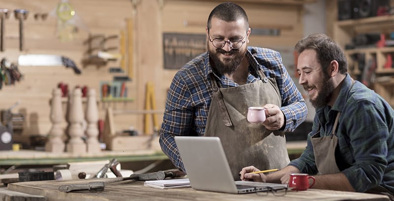 two men in a workshop on computer