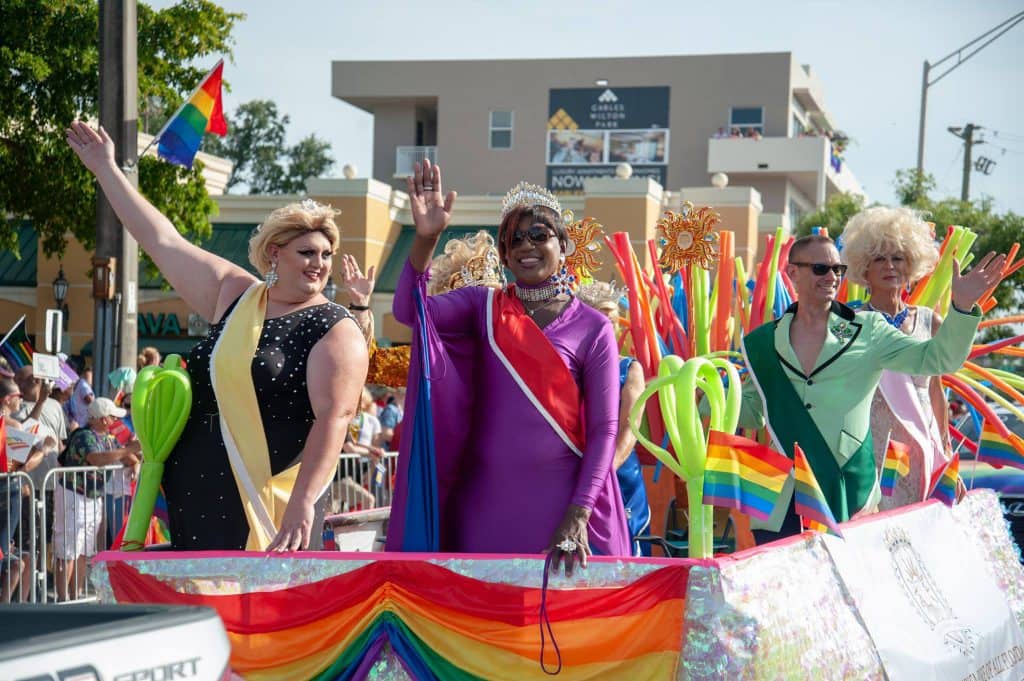 people waving on a float during a parade in Wilton Manors, Florida