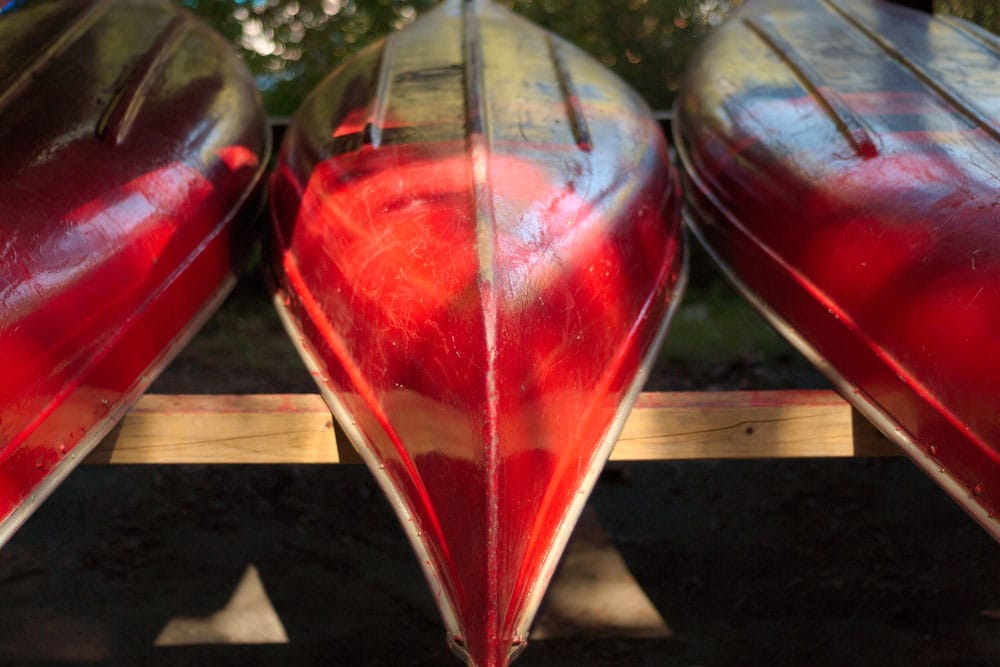 three red canoes lined up and stored