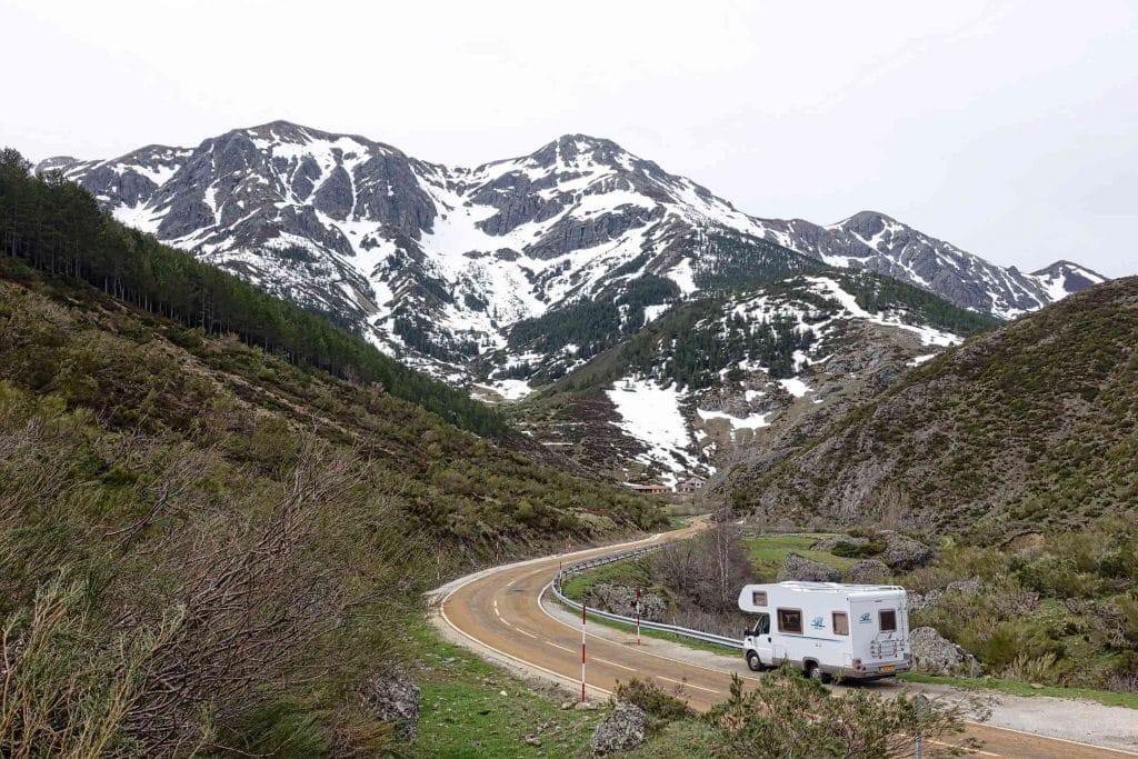 camper driving through snow capped mountains
