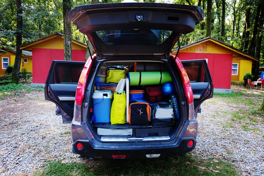 blue suv trunk open and filled with camping gear