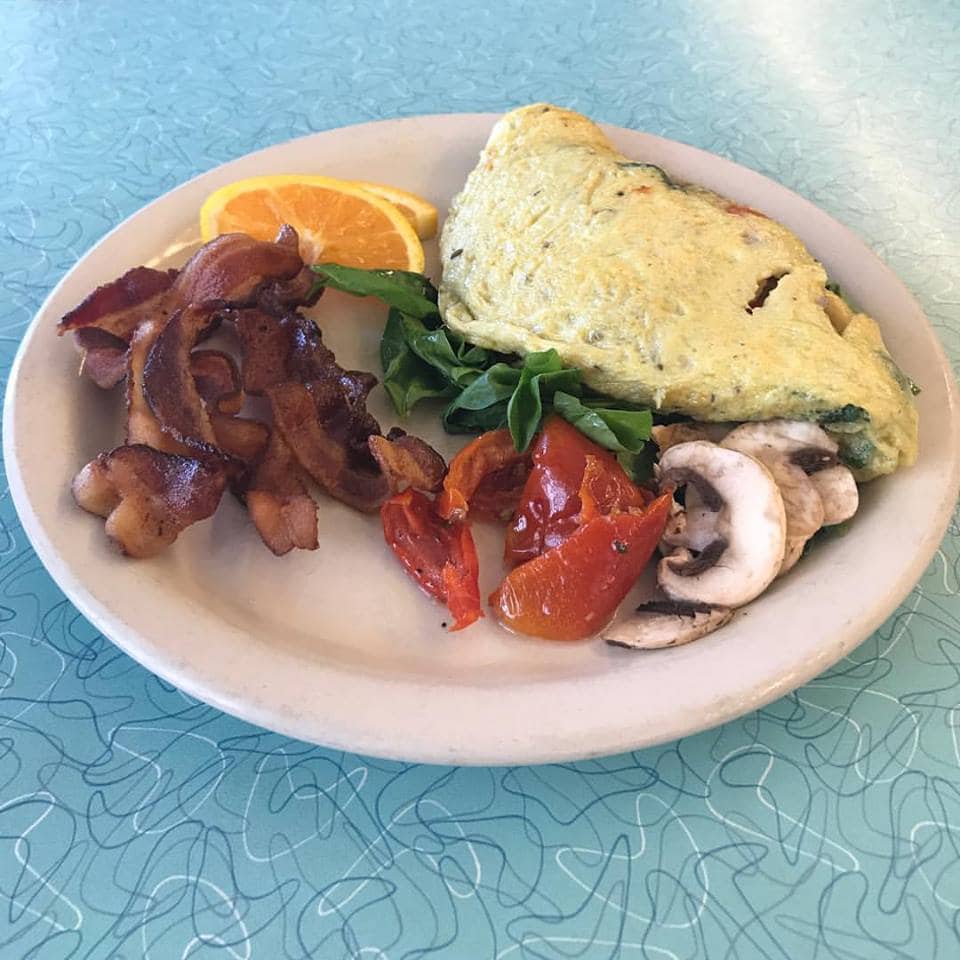 omelet with spinach, tomato, and mushrooms next to bacon from Home Grown in Atlanta