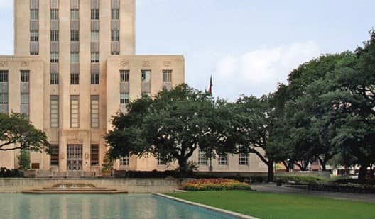 fountain and trees in front of Houston City Hall building