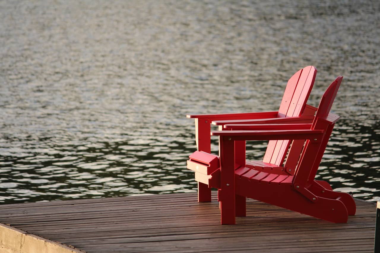 red Adirondack chairs on a pier