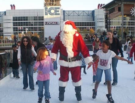 Santa skating outdoors with children