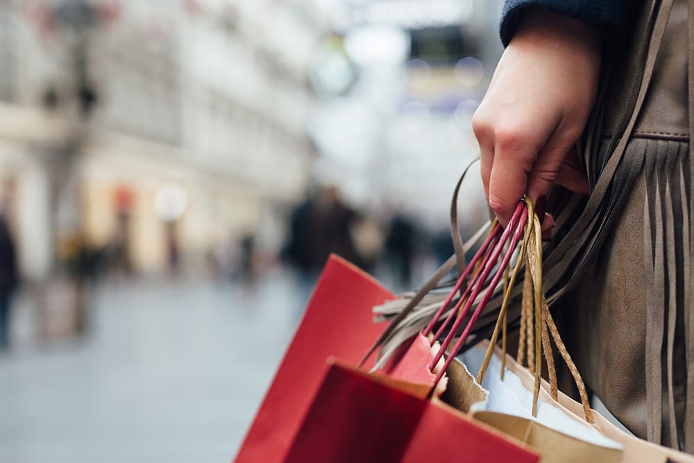 shopper holing several bags on a city street