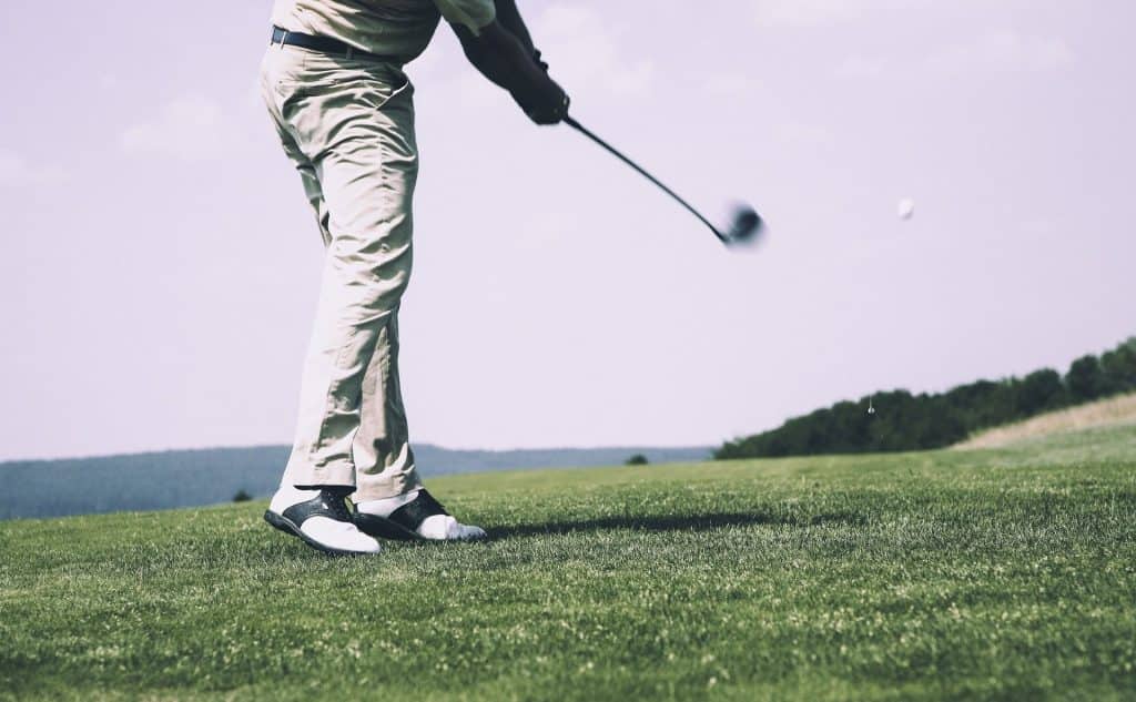 person hitting a golf ball at a golf course