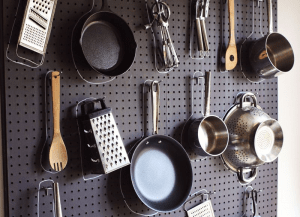 pots and pans hanging on a pegboard