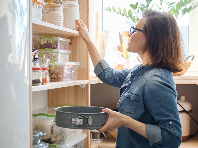 womanin kitchen pantry looking at shelves