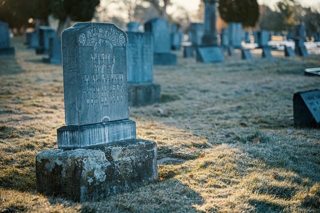 tombstone in cemetery at dusk