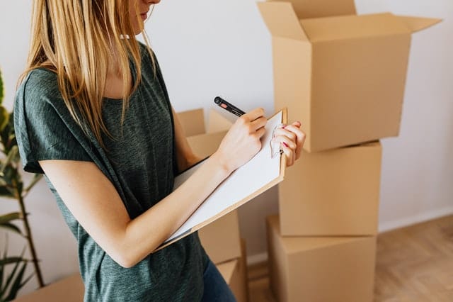 woman with moving boxes and clipboard