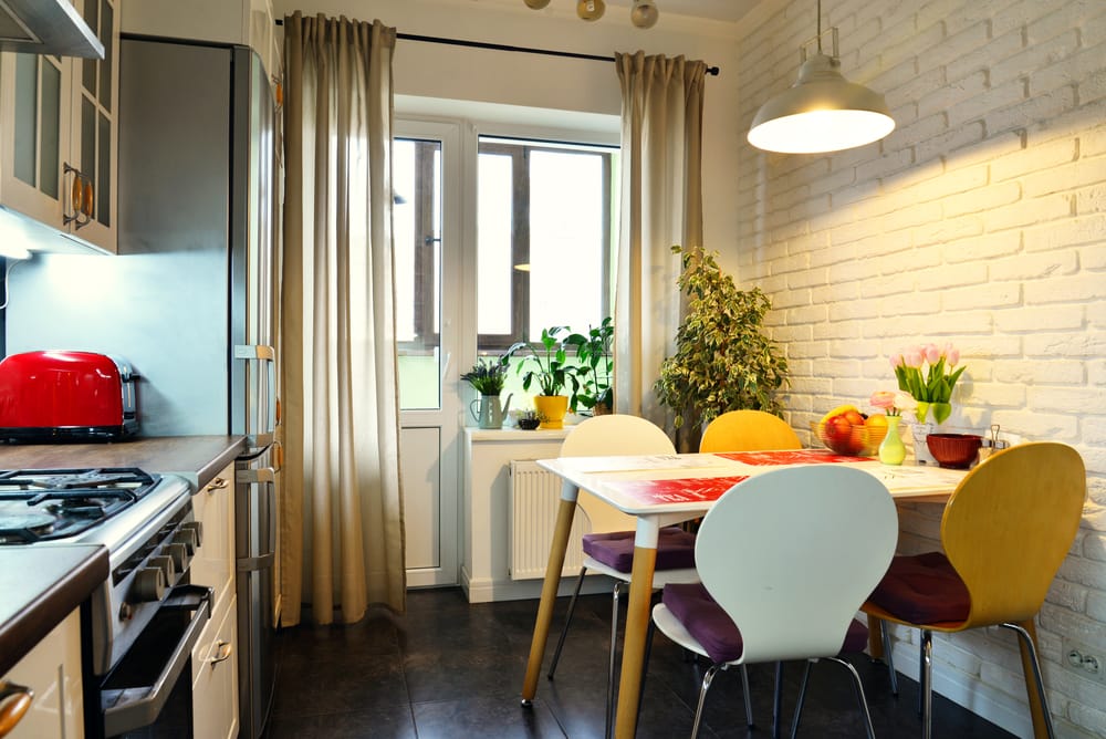 Interior of the kitchen in Scandinavian style with white furniture and a dining table