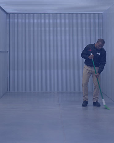 CubeSmart employee sweeping clean a unit